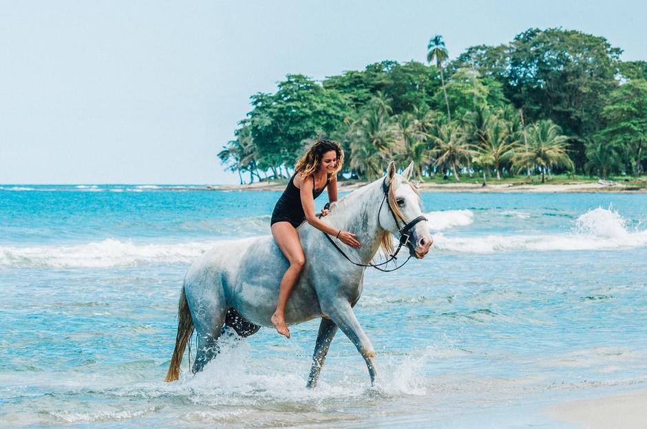 A girl riding a horse on a Costa Rica beach